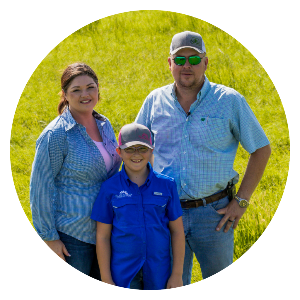 The Sugarek family stand together in a green field.