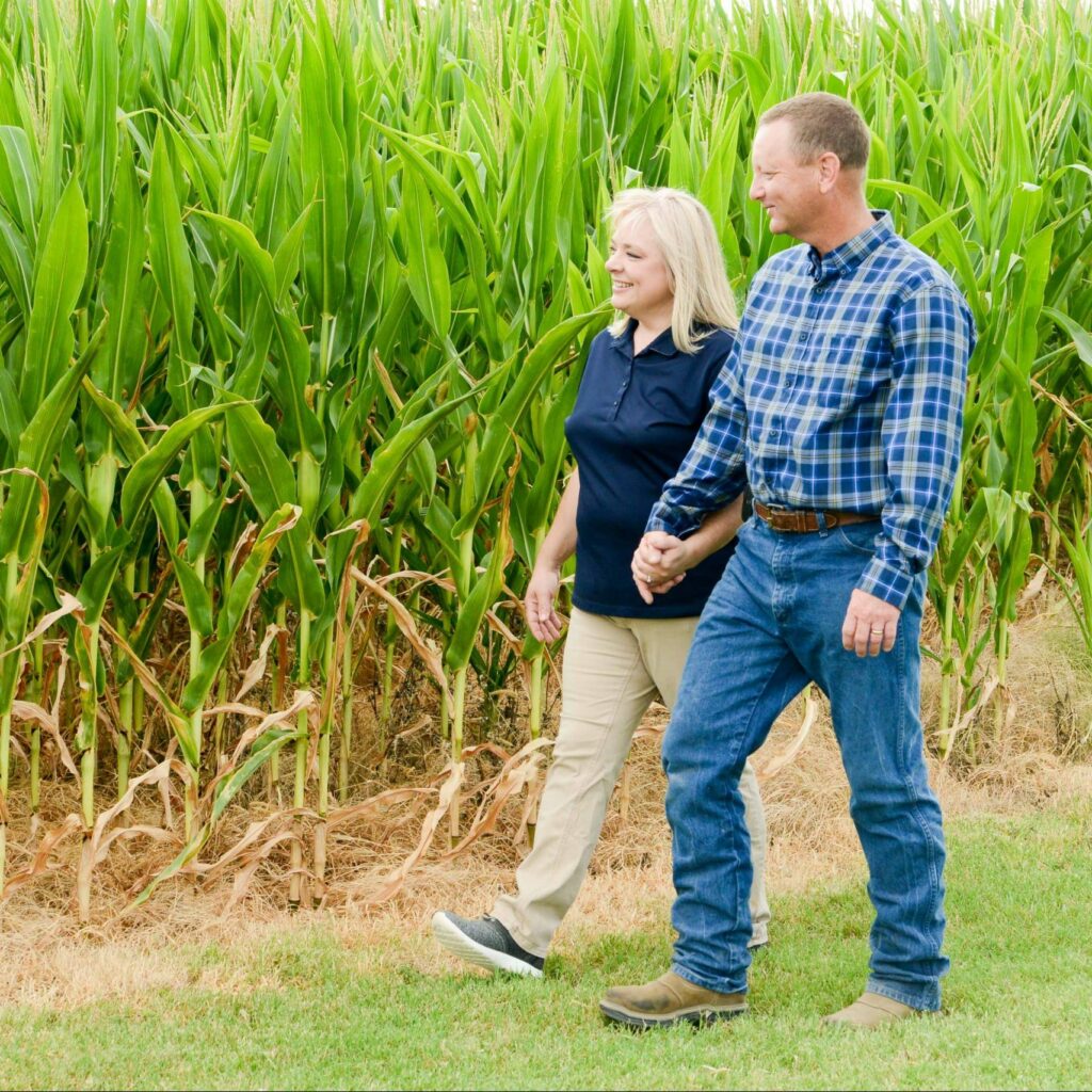 Texas farmers Randy and Susan Schronk walk alongside their corn field