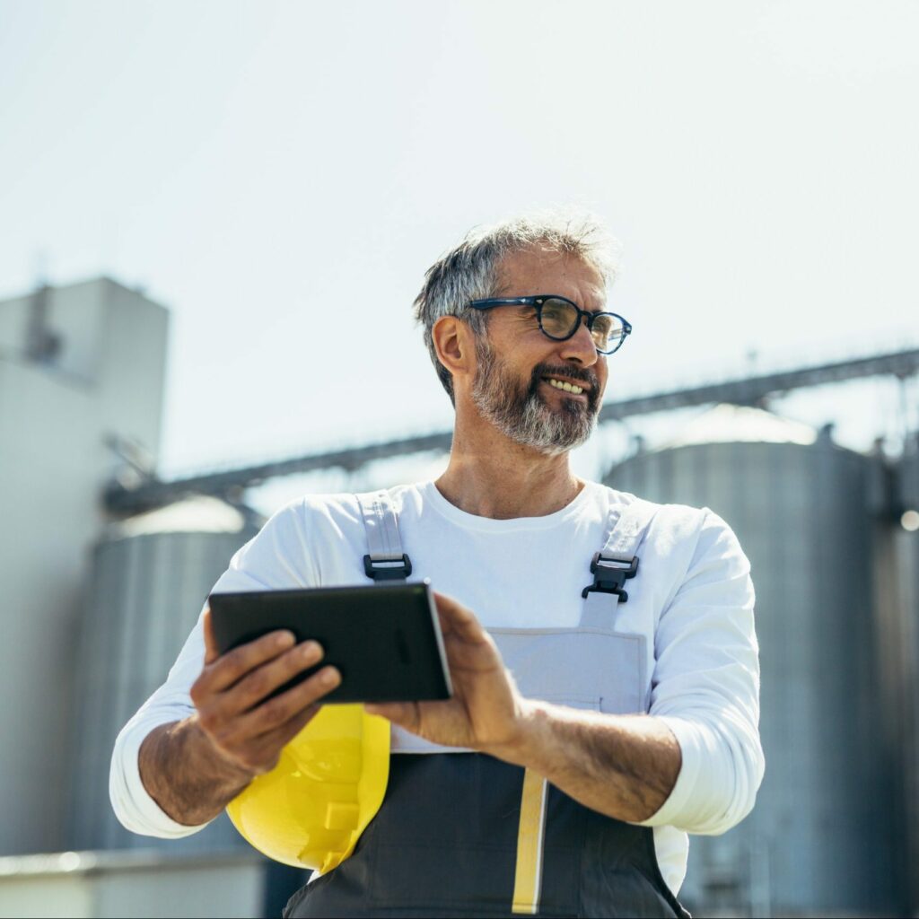 A worker using tablet in front of grain .