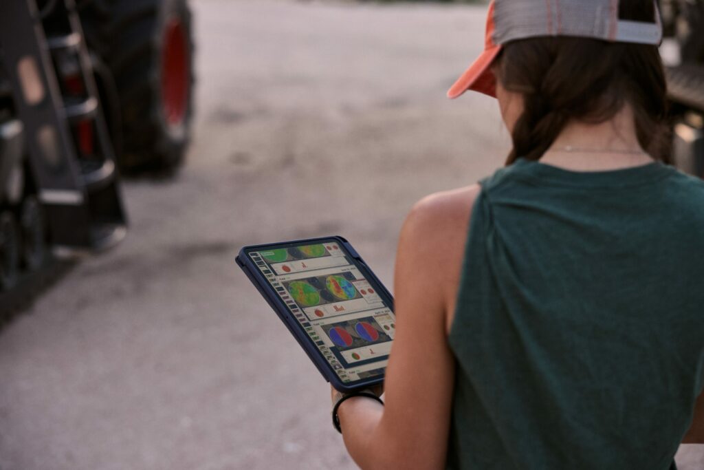 Farmer using technology on a tablet to monitor field data.